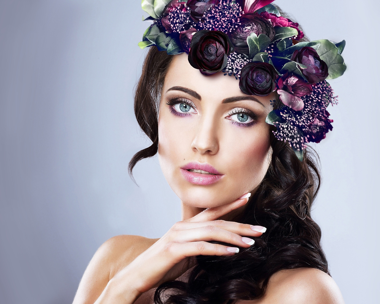 Красивая голубоглазая девушка с венком на голове на сером фоне