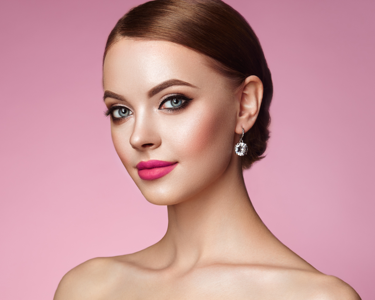 Красивая голубоглазая девушка с красивыми серьгами на розовом фоне