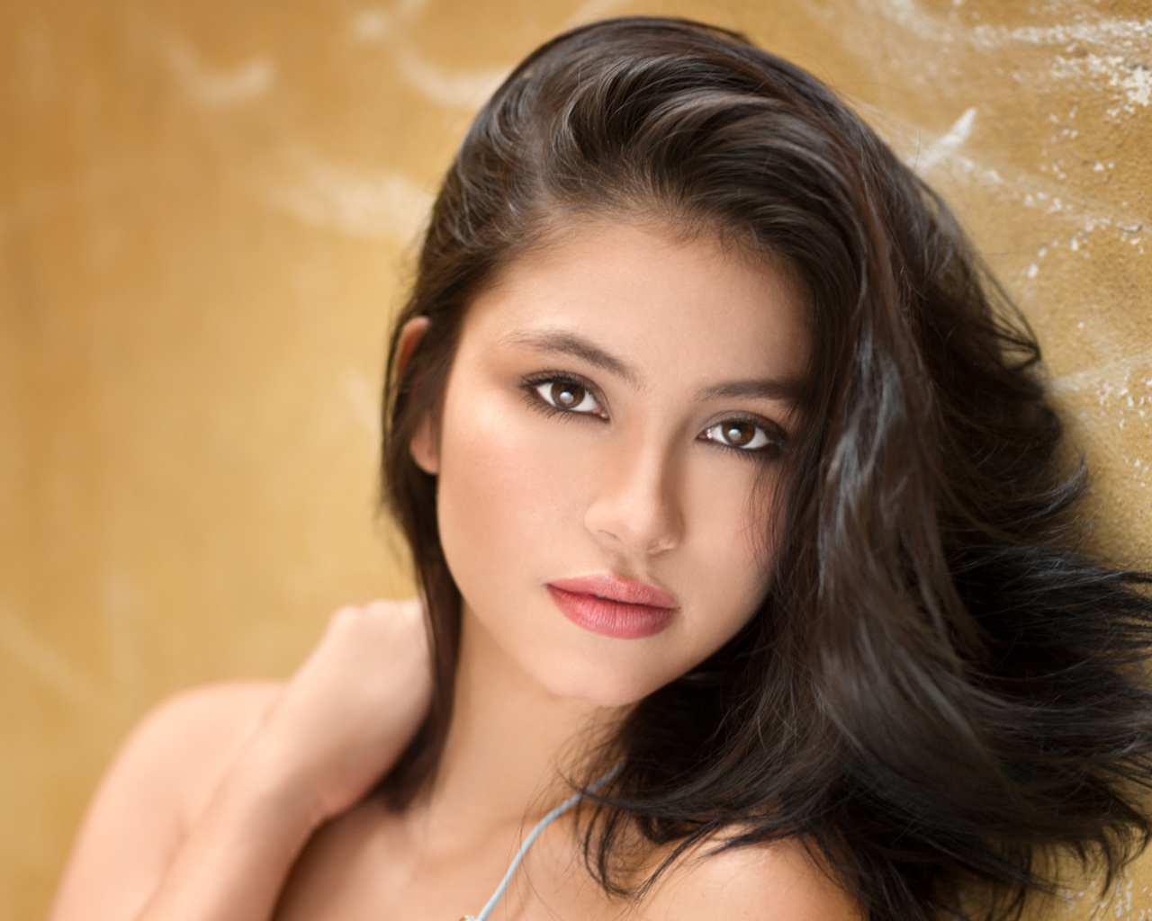 Красивая брюнетка на фоне стены 