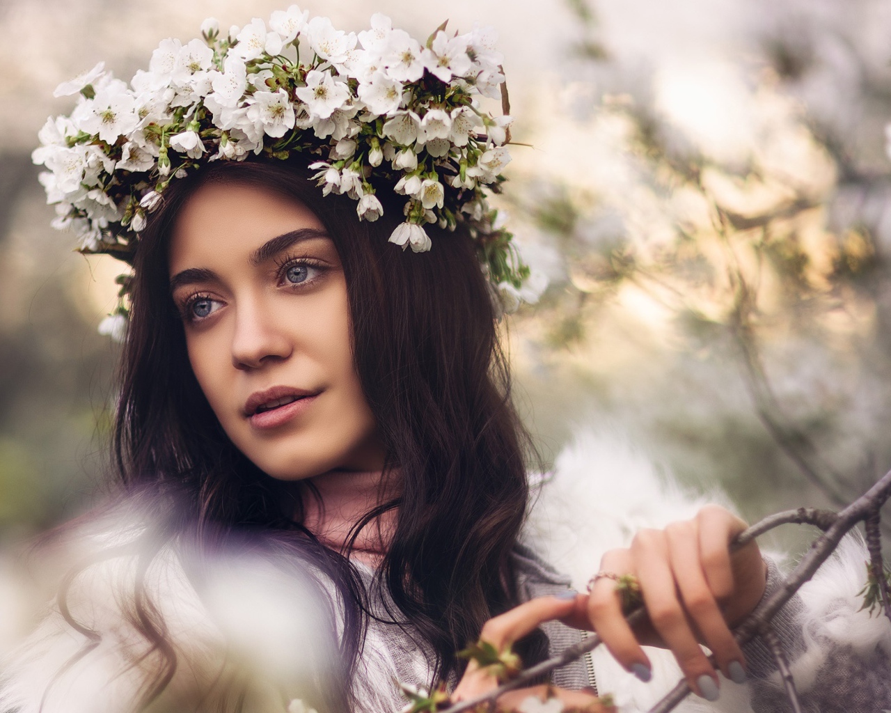 Красивая брюнетка с венком из цветов вишни на голове