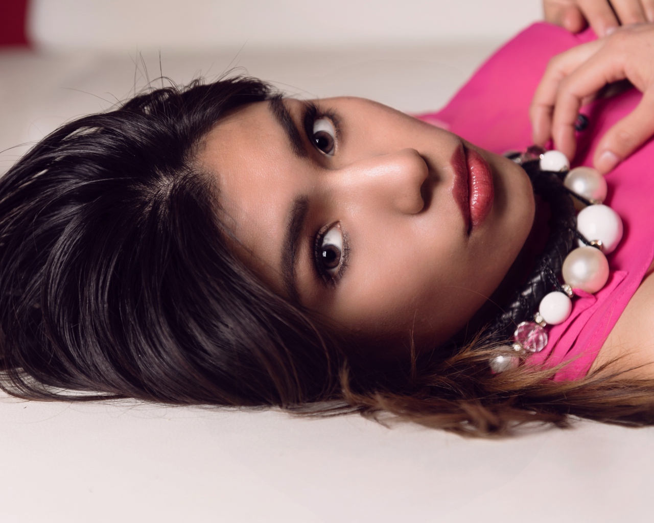 Красивая брюнетка с большими бусами на шее