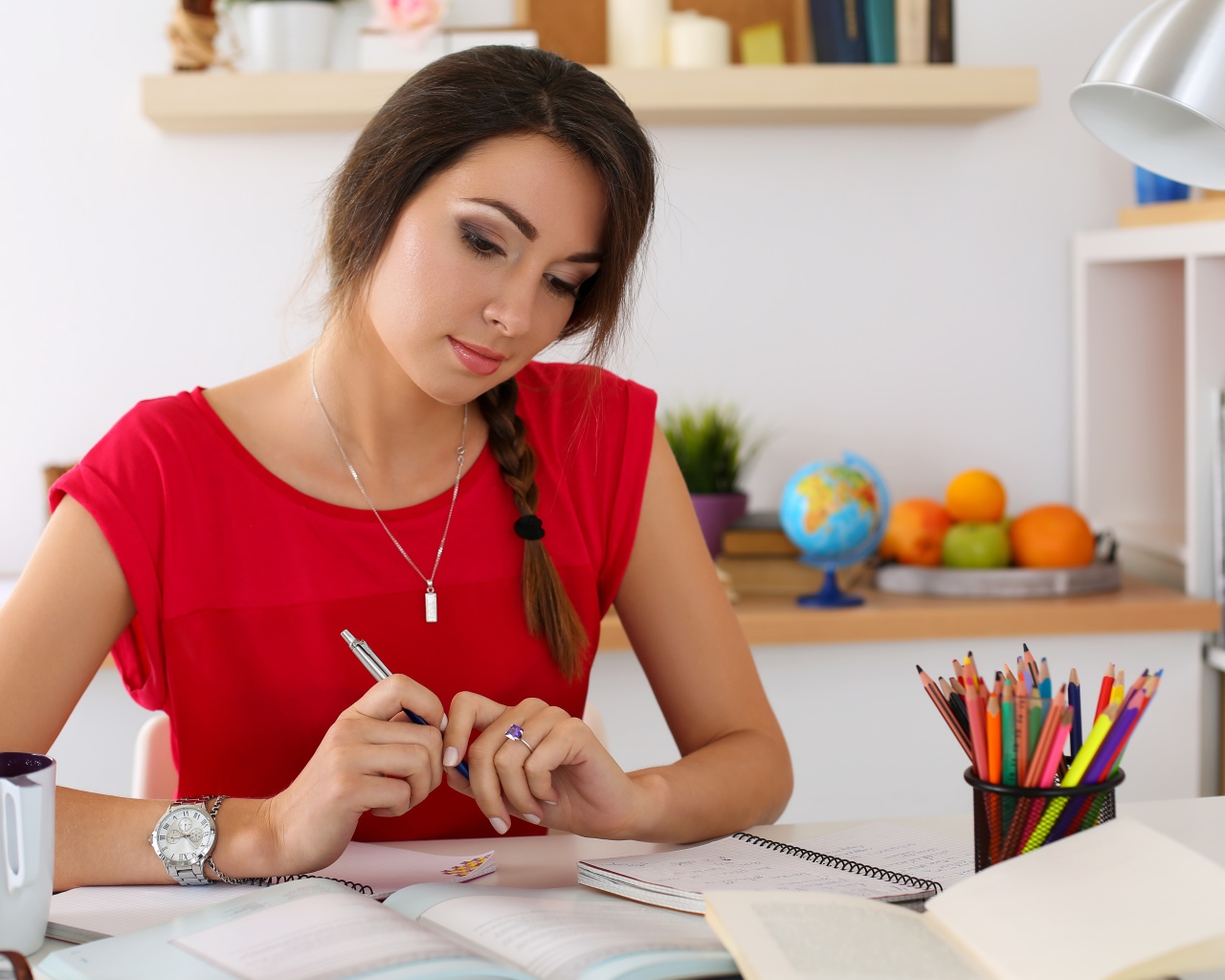 Красивая деловая девушка за столом с тетрадями