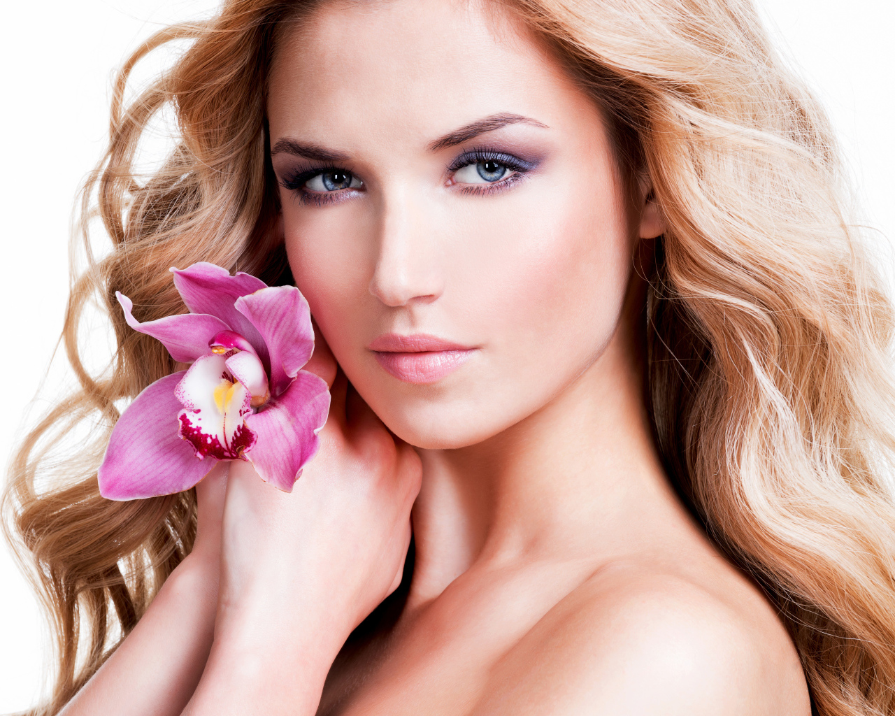 Красивая нежная блондинка с цветком орхидеи на белом фоне