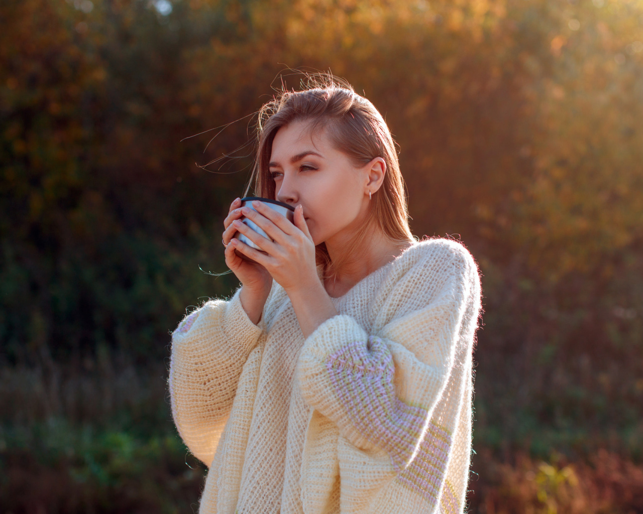 Красивая девушка пьет чай в теплом свитере