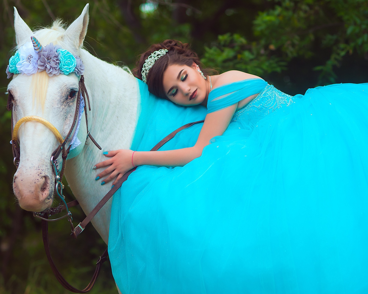 Красивая девушка в пышном голубом платье на лошади