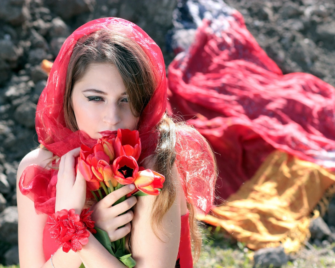 Красивая девушка в красной шали с букетом тюльпанов