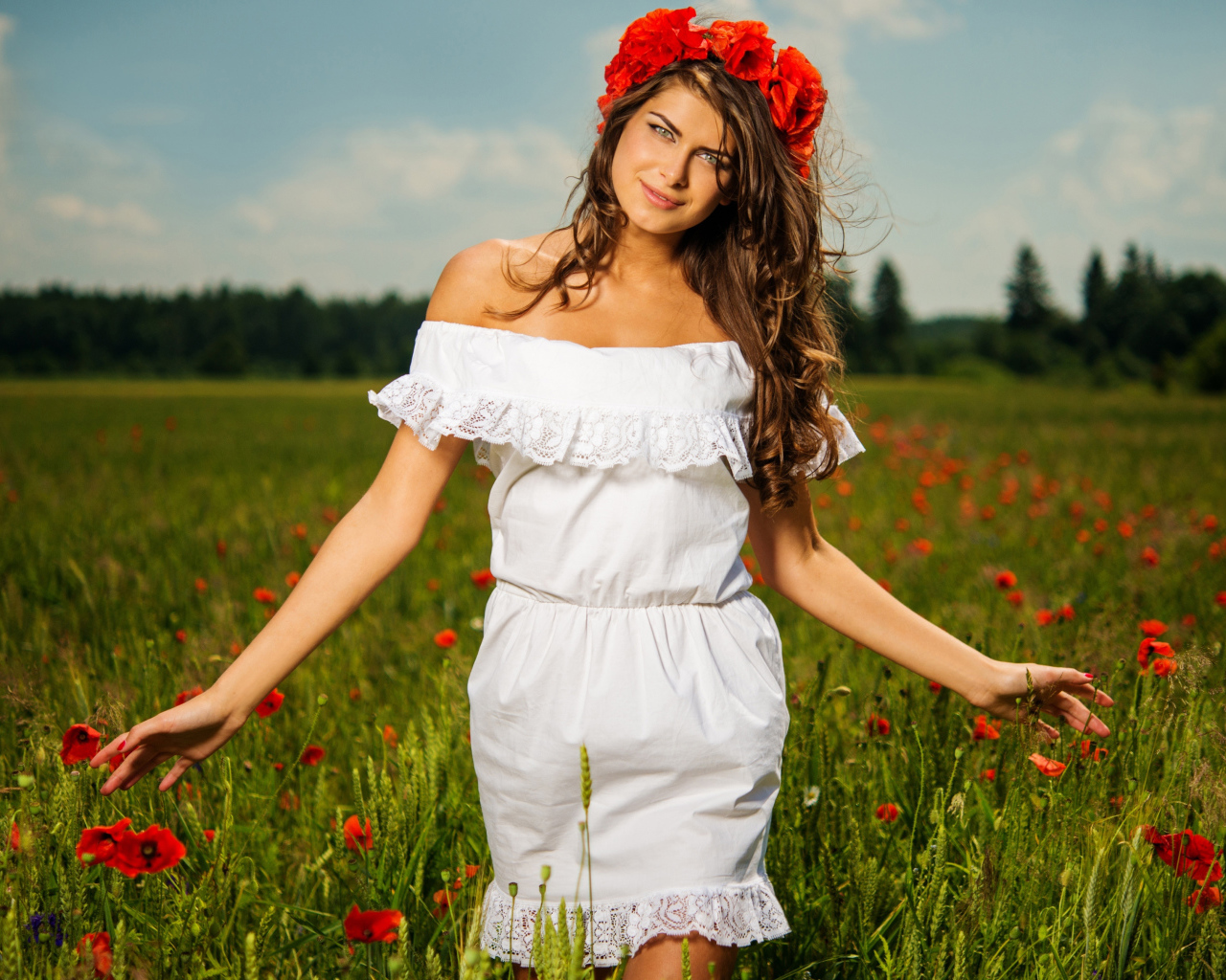 Красивая девушка в белом платье с венком из красных маков на голове 