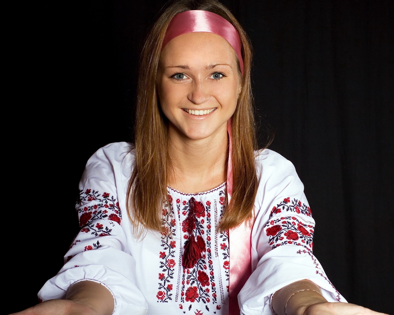 Красивая девушка в вышитой рубашке на черном фоне