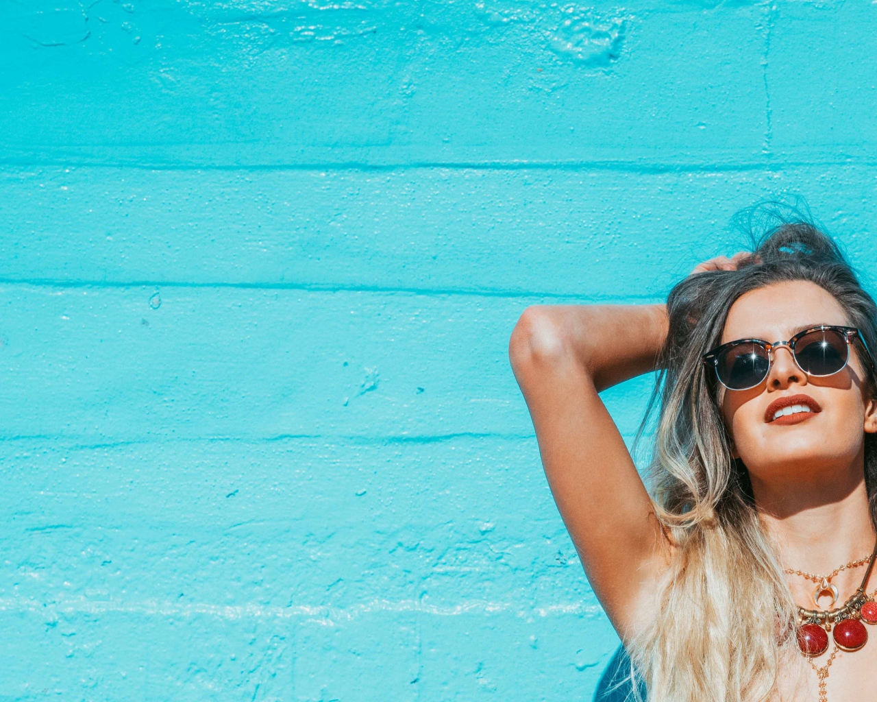 Красивая девушка в солнечных очках загорает на солнце летом