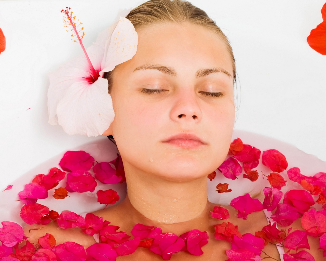 Красивая девушка в ванной с лепестками розы 