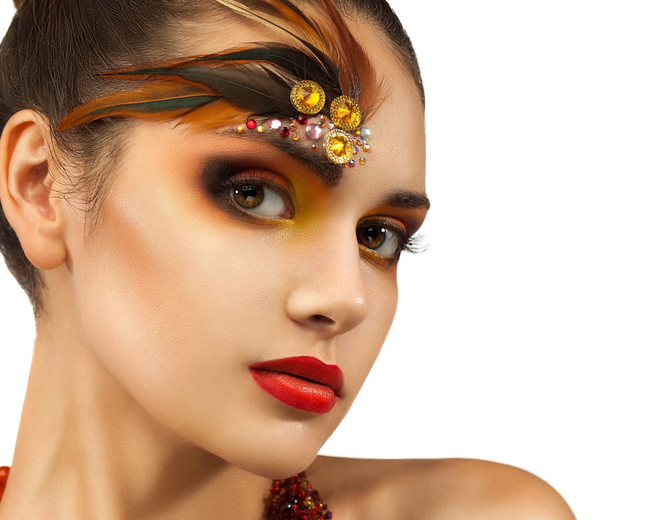 Красивая девушка с ярким макияжем и стразами на лице