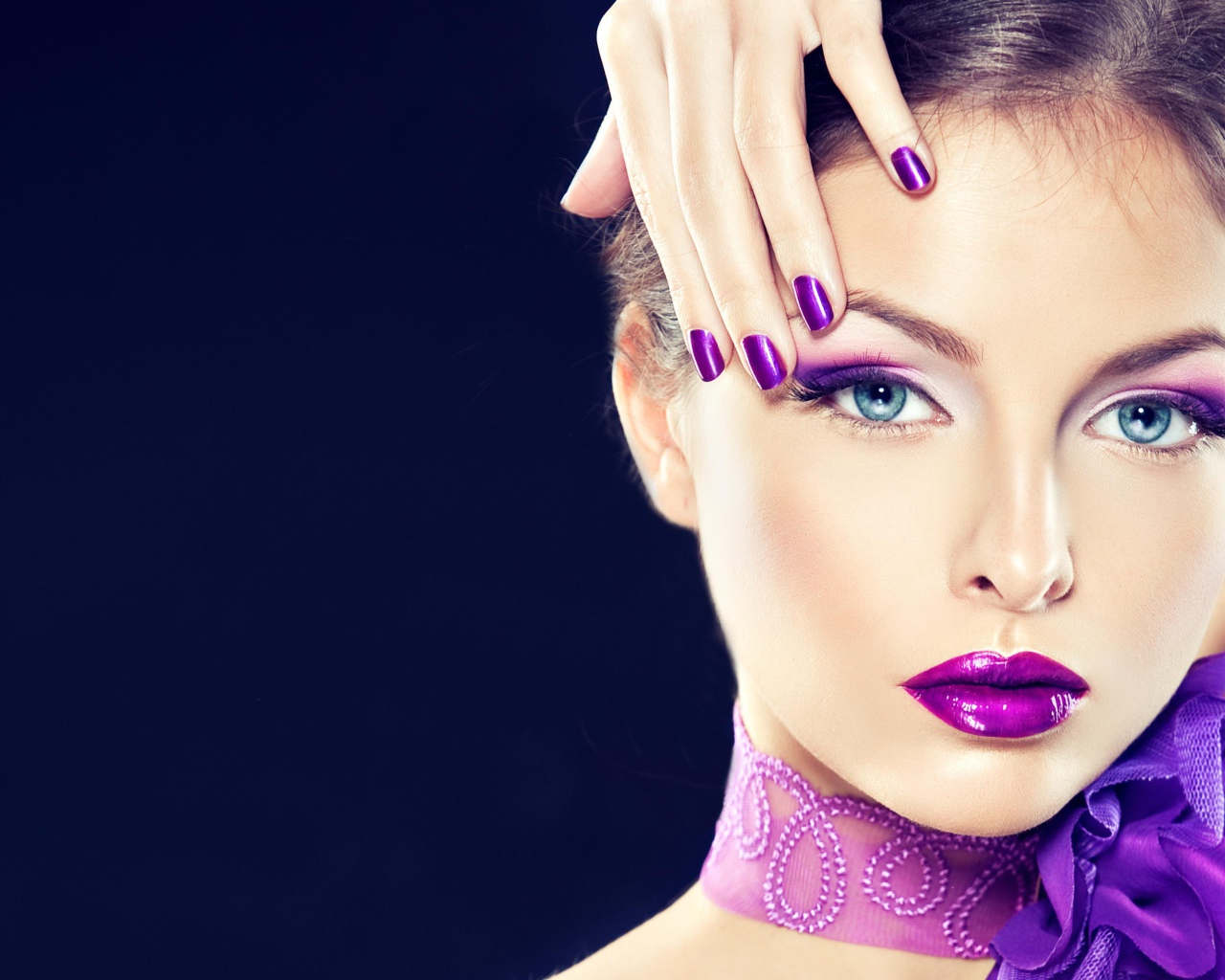 Красивая девушка с ярким фиолетовым макияжем с рукой у лица