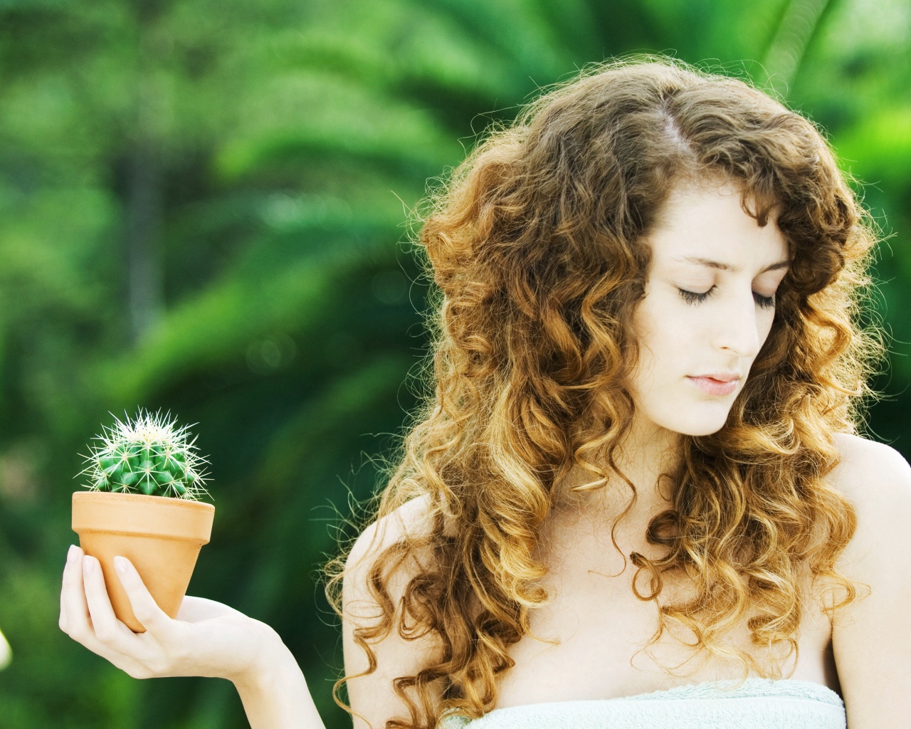Красивая девушка с закрытыми глазами с кактусом в руке