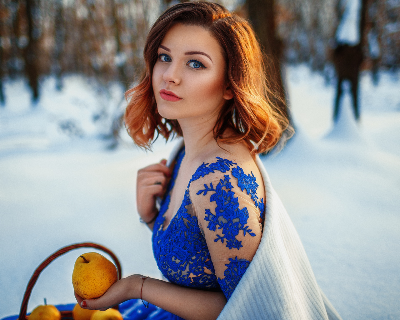 Красивая девушка с грушами в заснеженном лесу