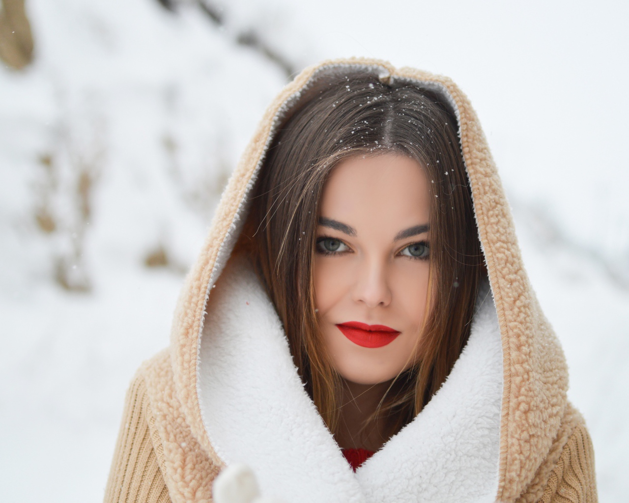 Красивая девушка с красными губами в теплой куртке зимой