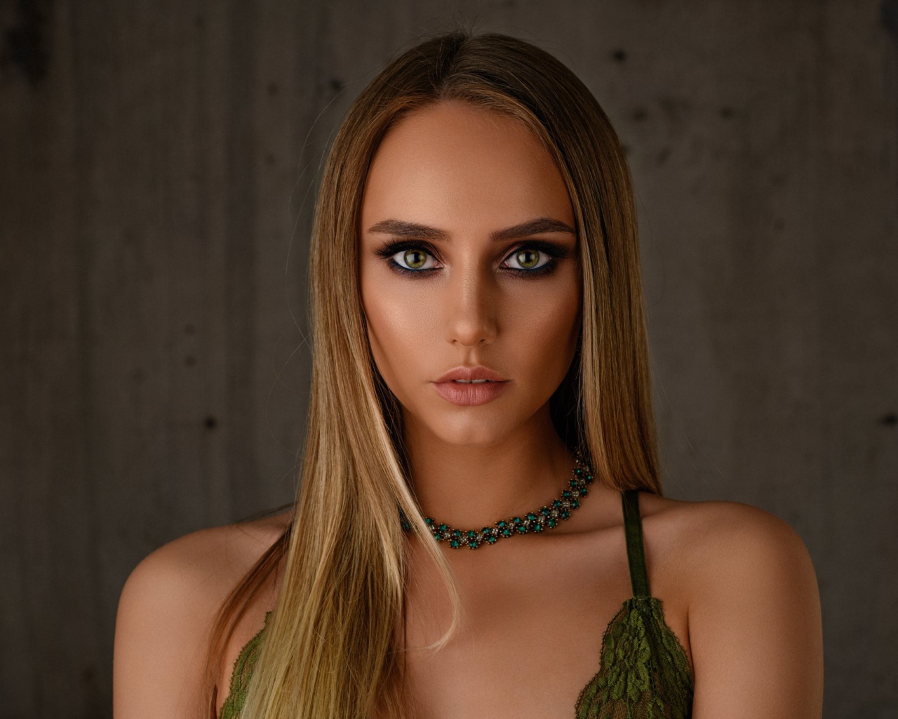 Красивая длинноволосая блондинка с украшением на шее 