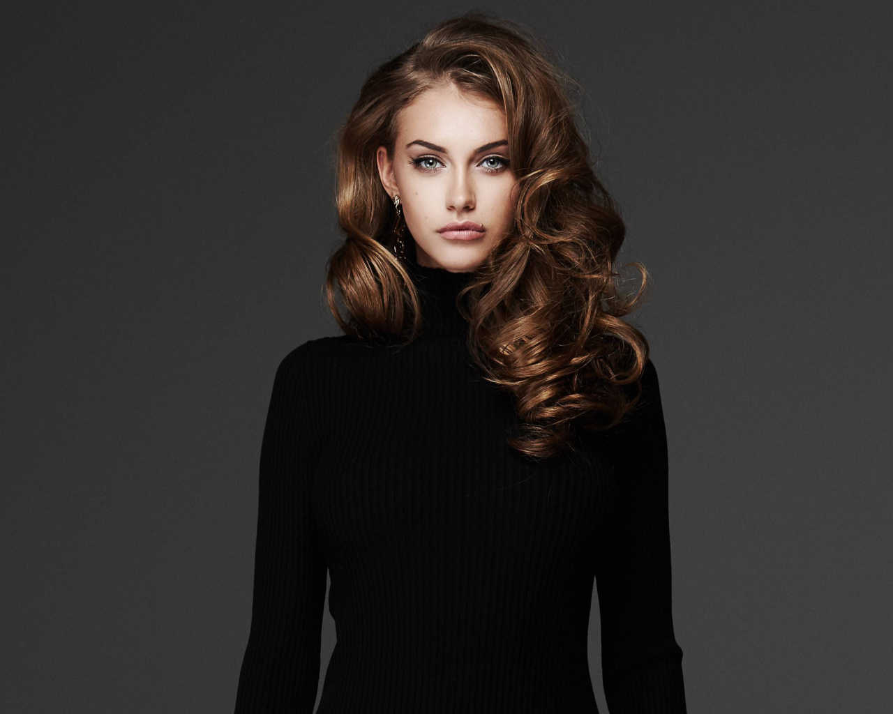 Красивая длинноволосая брюнетка в черном свитере