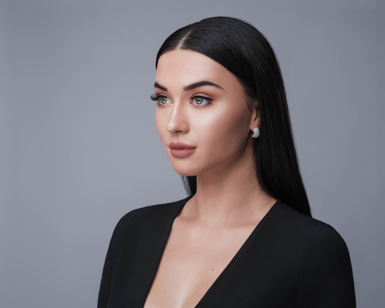 Красивая длинноволосая брюнетка в черном фото на сером фоне