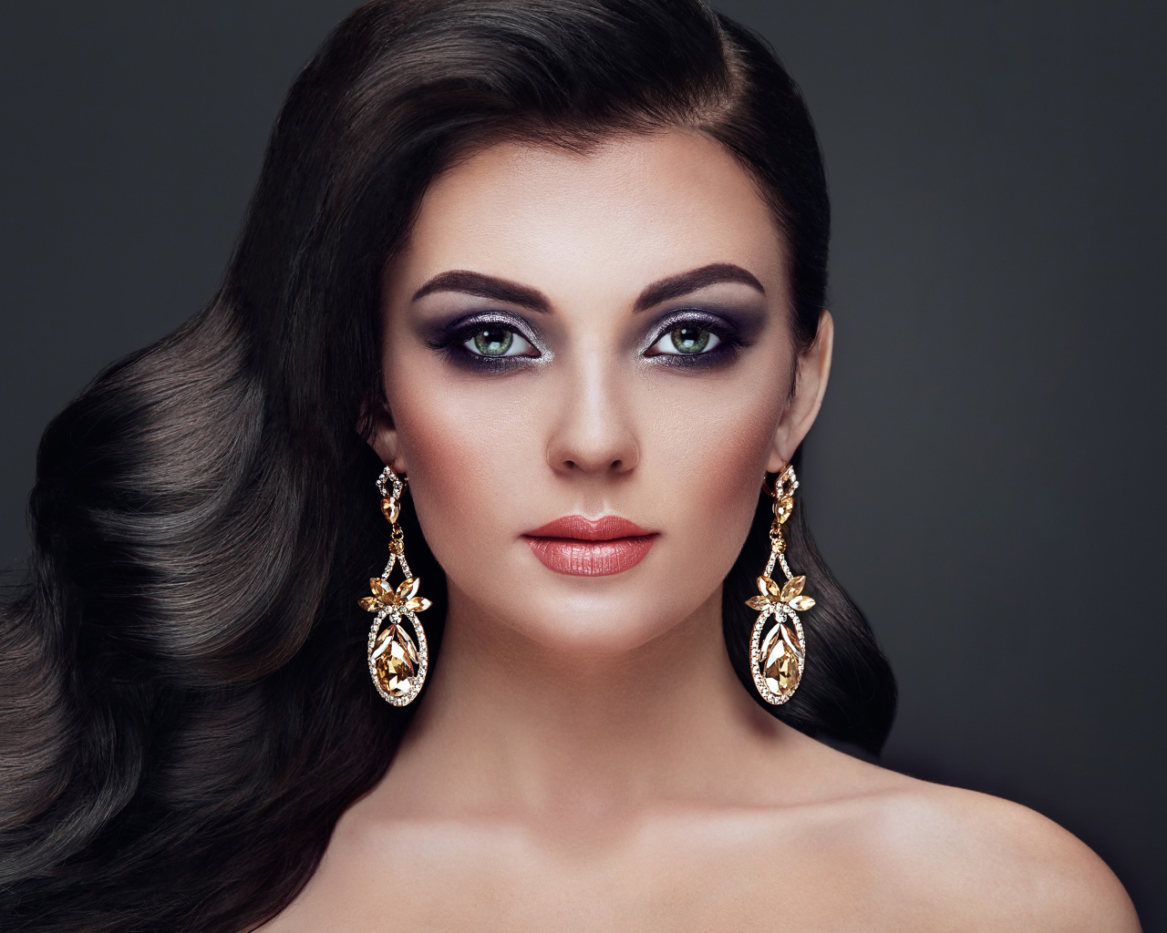 Красивая длинноволосая девушка с ярким макияжем и длинными серьгами