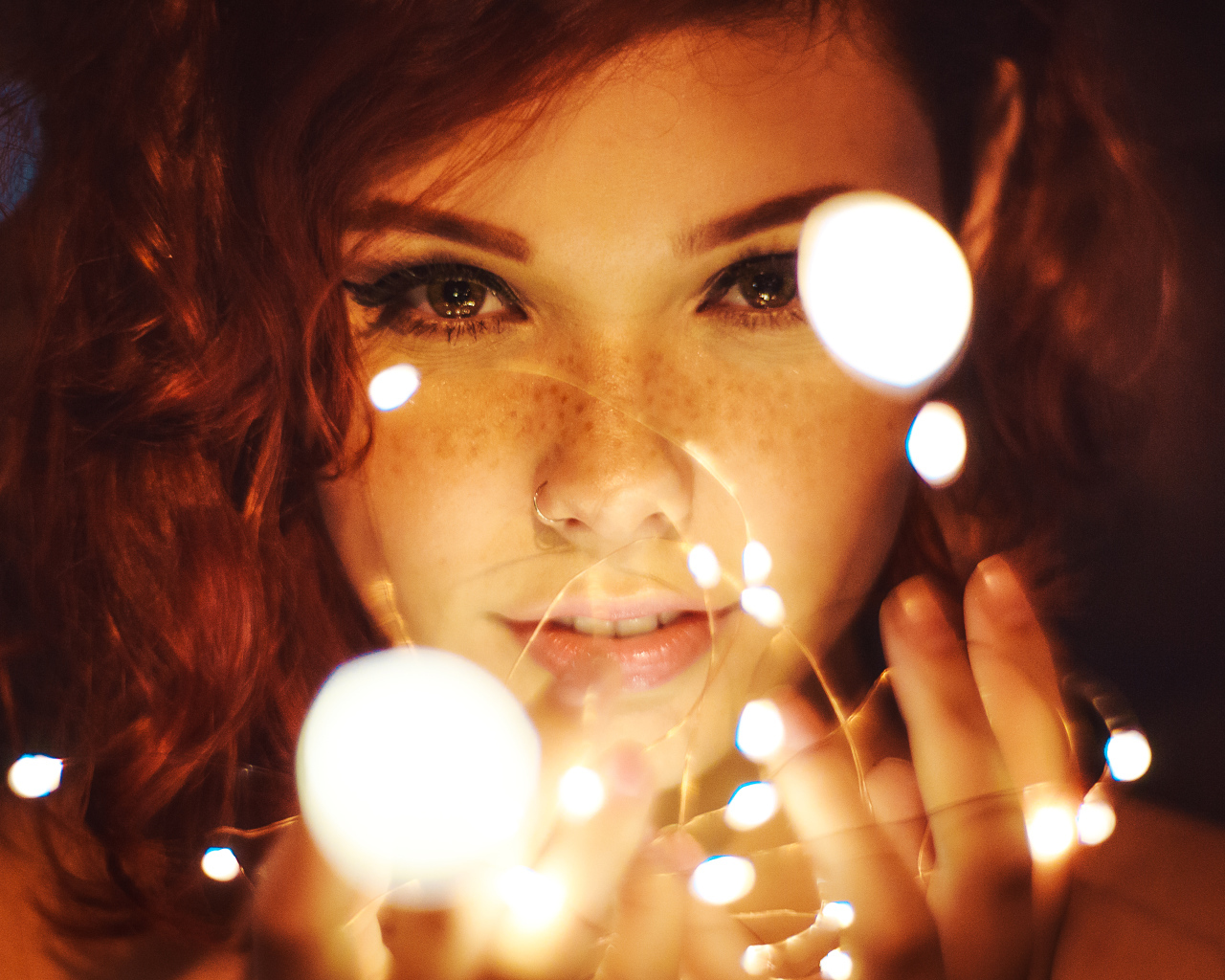 Красивая рыжеволосая девушка с гирляндой в руках 