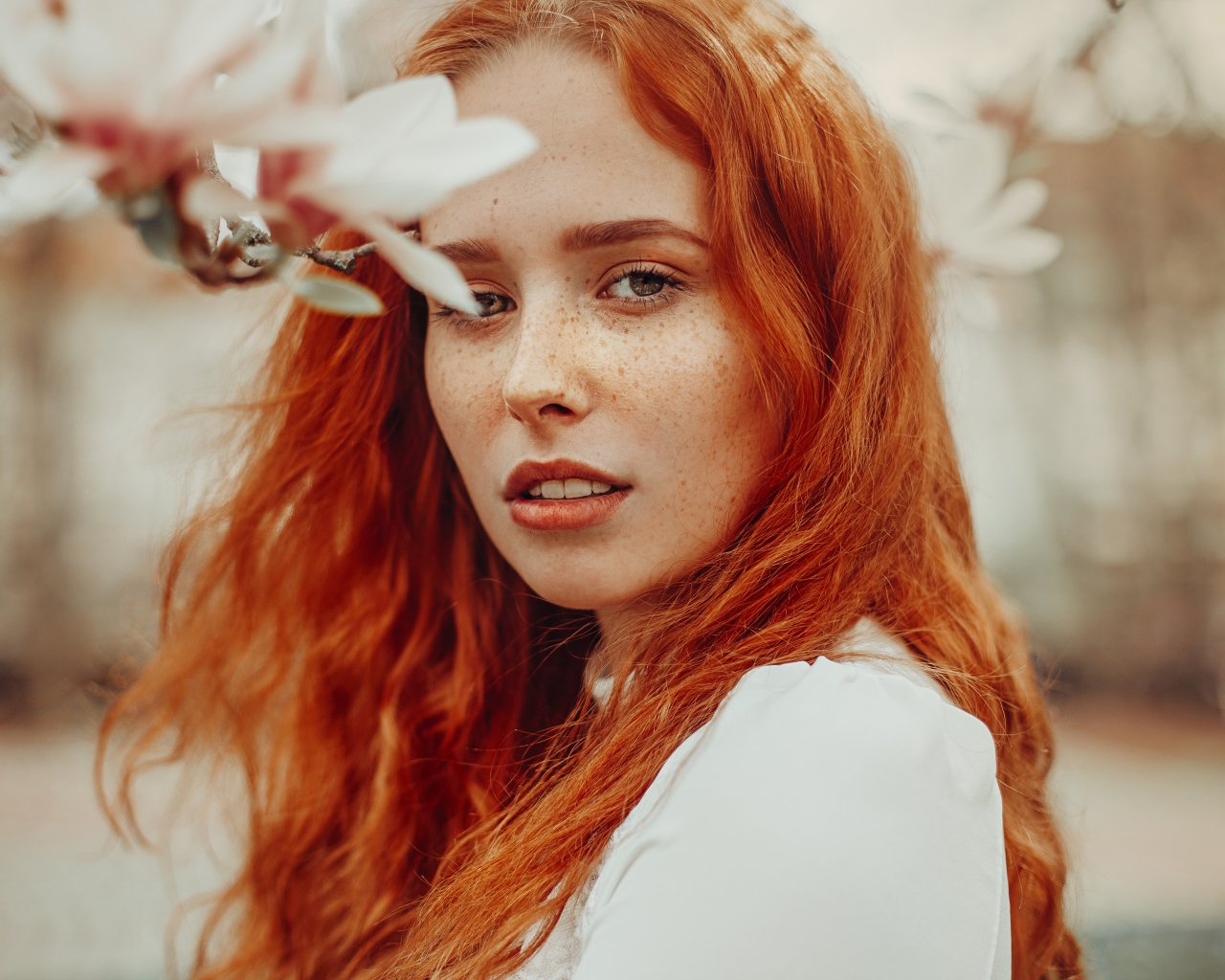 Красивая рыжеволосая девушка с веснушками на лице