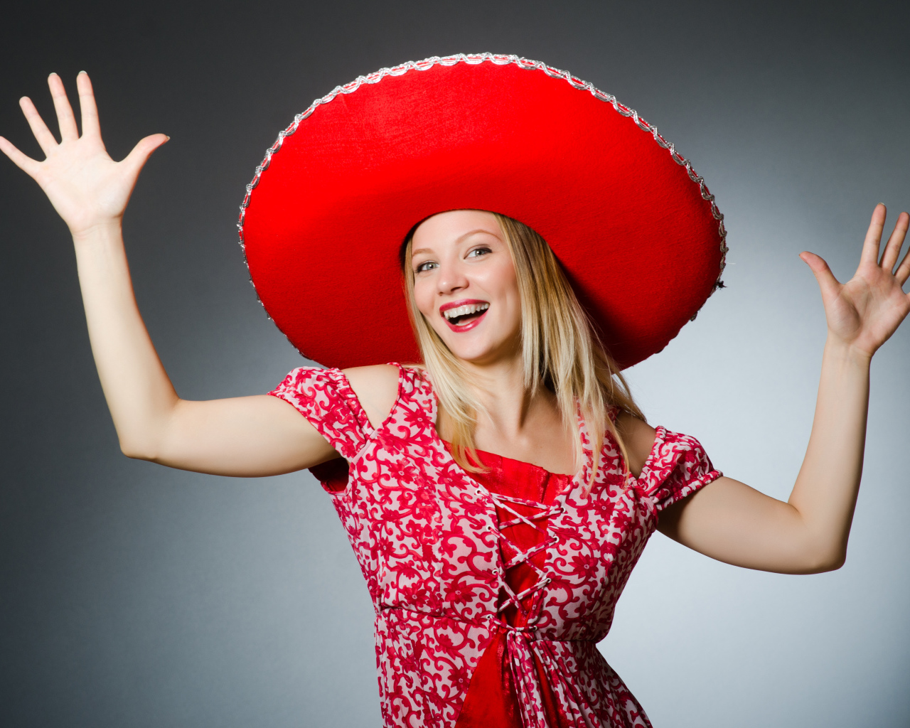 Красивая улыбающаяся блондинка в большой красной шляпе