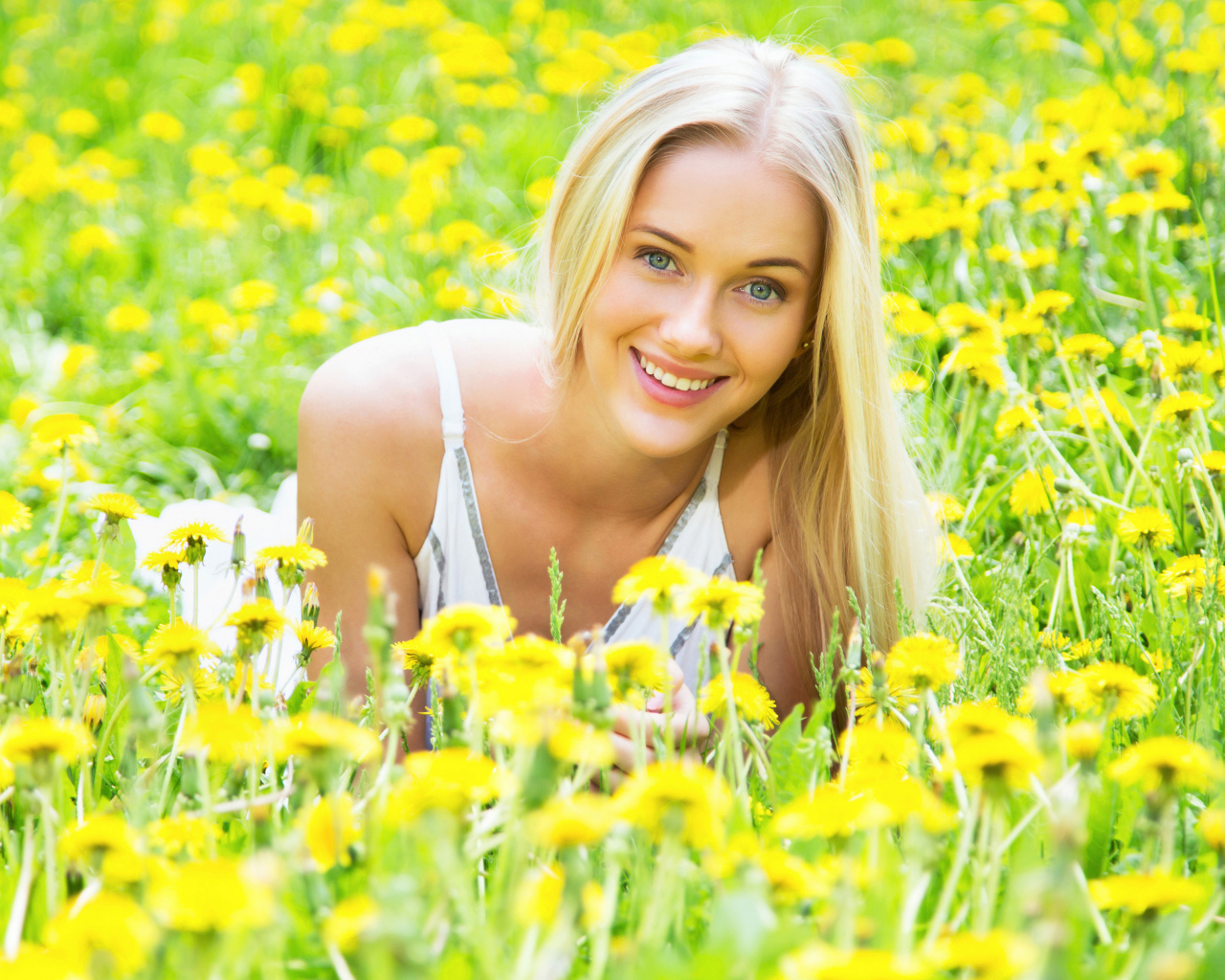 Красивая улыбающаяся блондинка в желтых одуванчиках