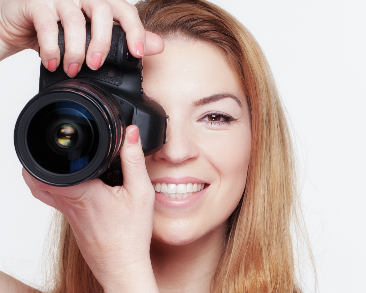 Красивая улыбающаяся девушка с фотоаппаратом