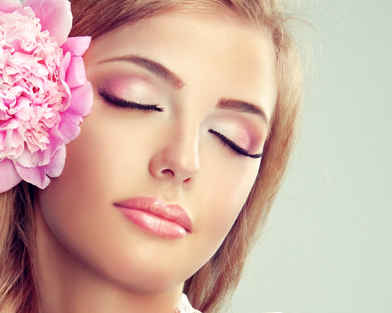 Красивая нежная молодая девушка с розовым цветком пиона в волосах 