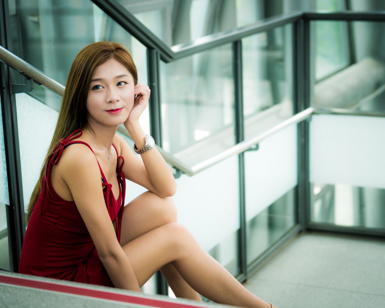 Красивая молодая девушка азиатка сидит на ступенях