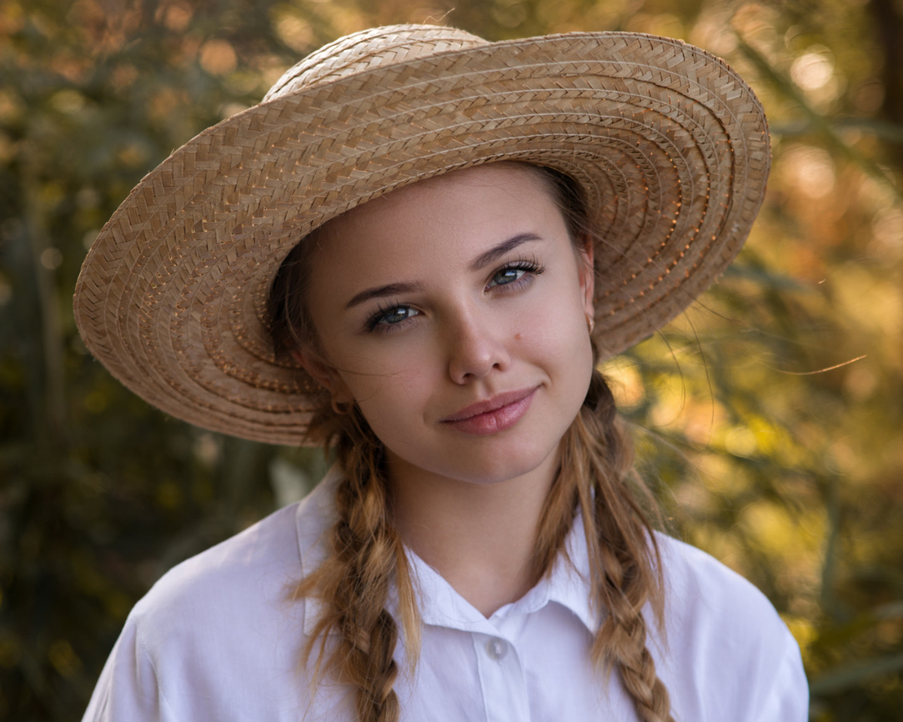 Красивая молодая девушка в соломенной шляпе