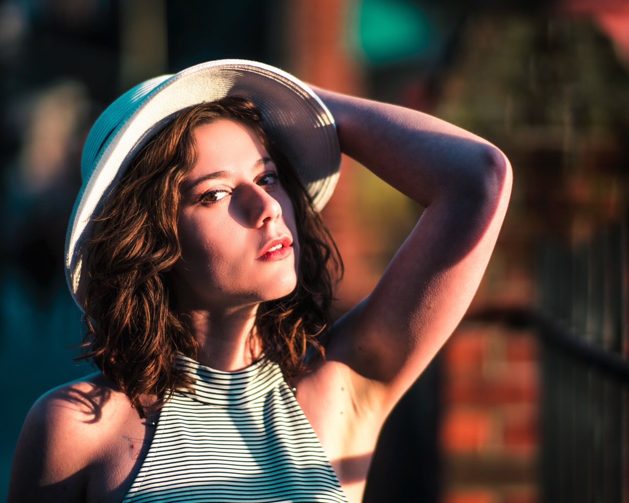 Красивая молодая девушка в белой шляпе в свете солнца