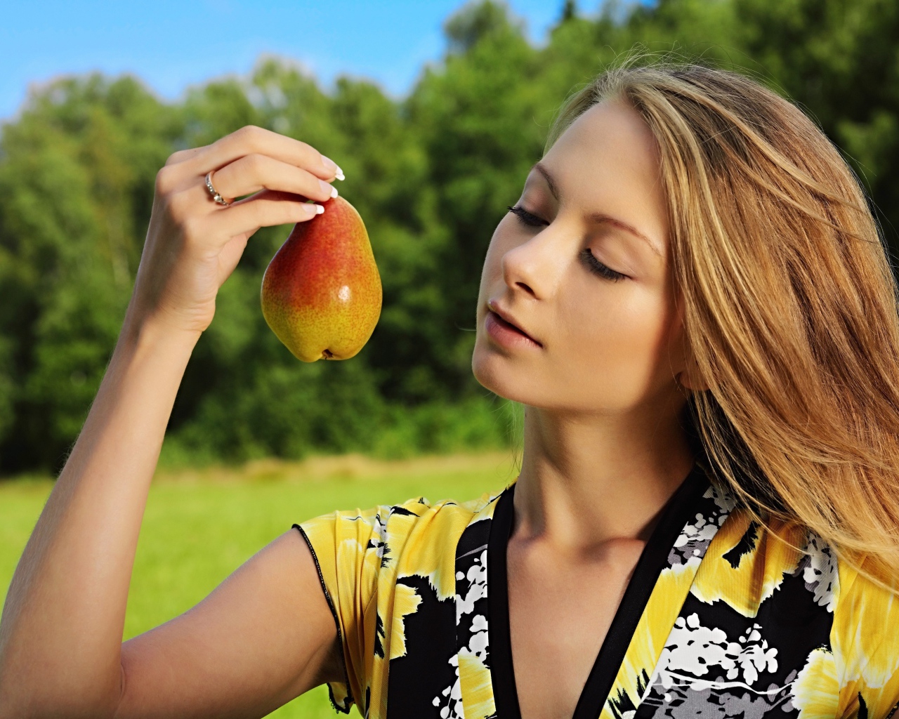 Красивая молодая девушка с грушей в руках