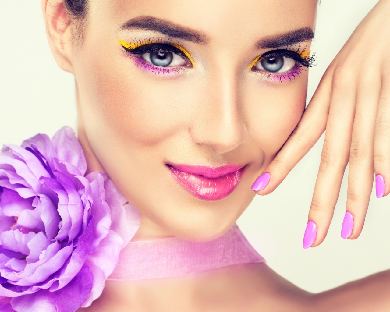 Красивая молодая девушка с ярким макияжем и сиреневым цветком на шее