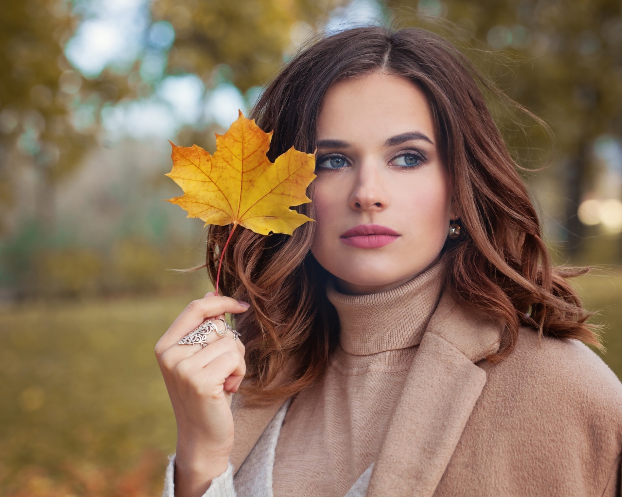 Красивая молодая девушка шатенка с желтым листом в руке