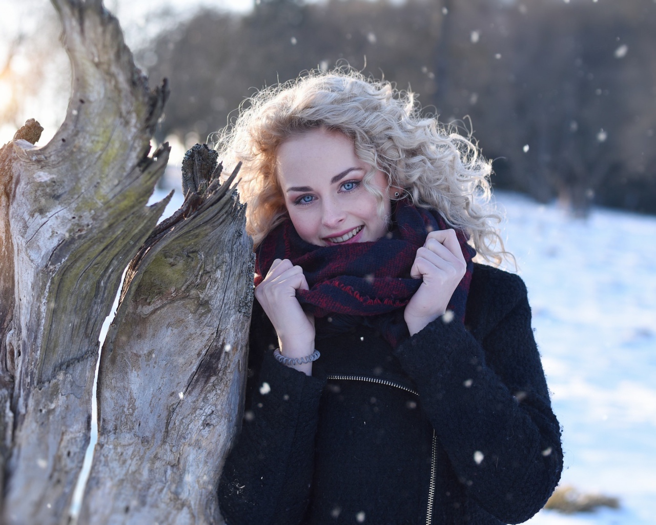 Голубоглазая блондинка у сухого дерева зимой