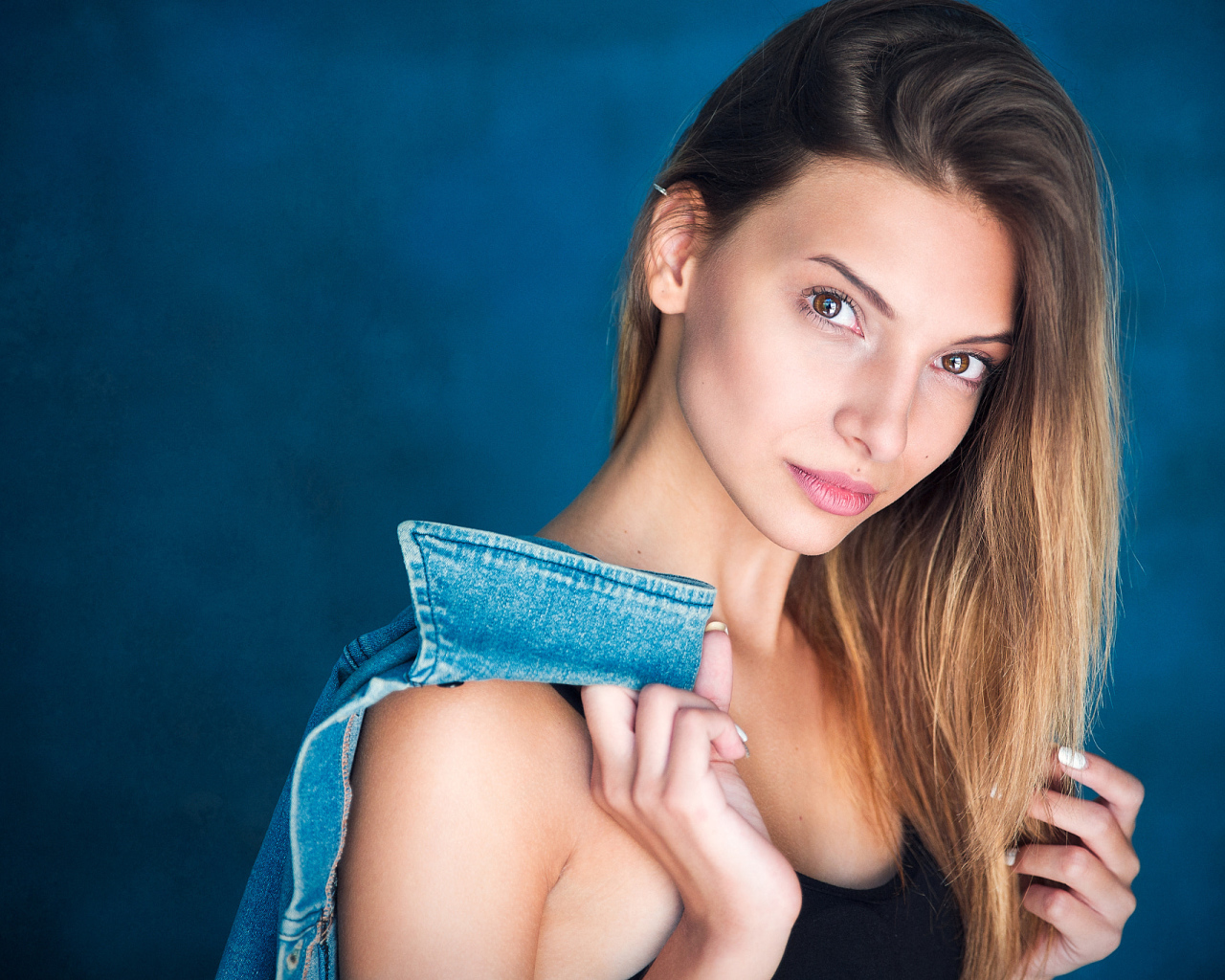 Кареглазая шатенка с джинсовой курткой в руке