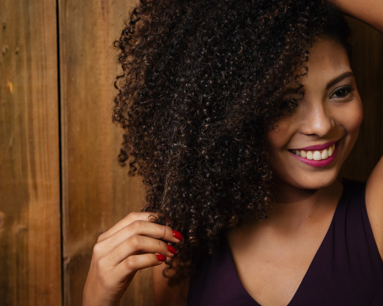 Кучерявая темнокожая девушка с красивой улыбкой 