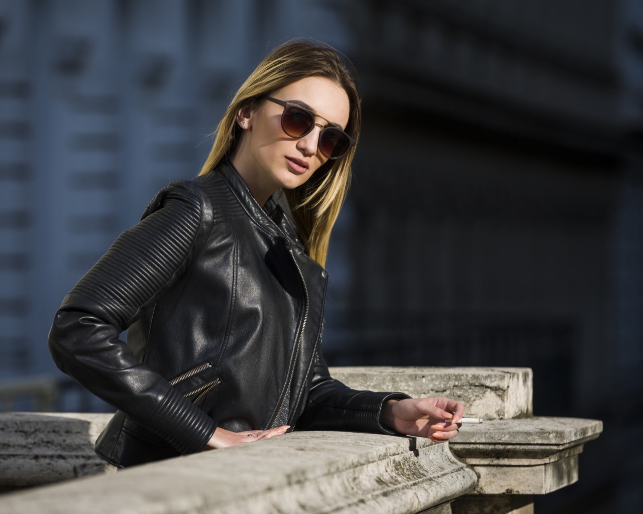 Дерзкая девушка в черной кожаной куртке и очках