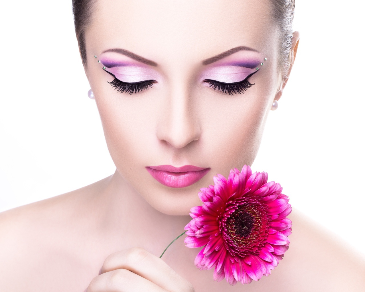 Нежная девушка с розовым цветком герберы на белом фоне