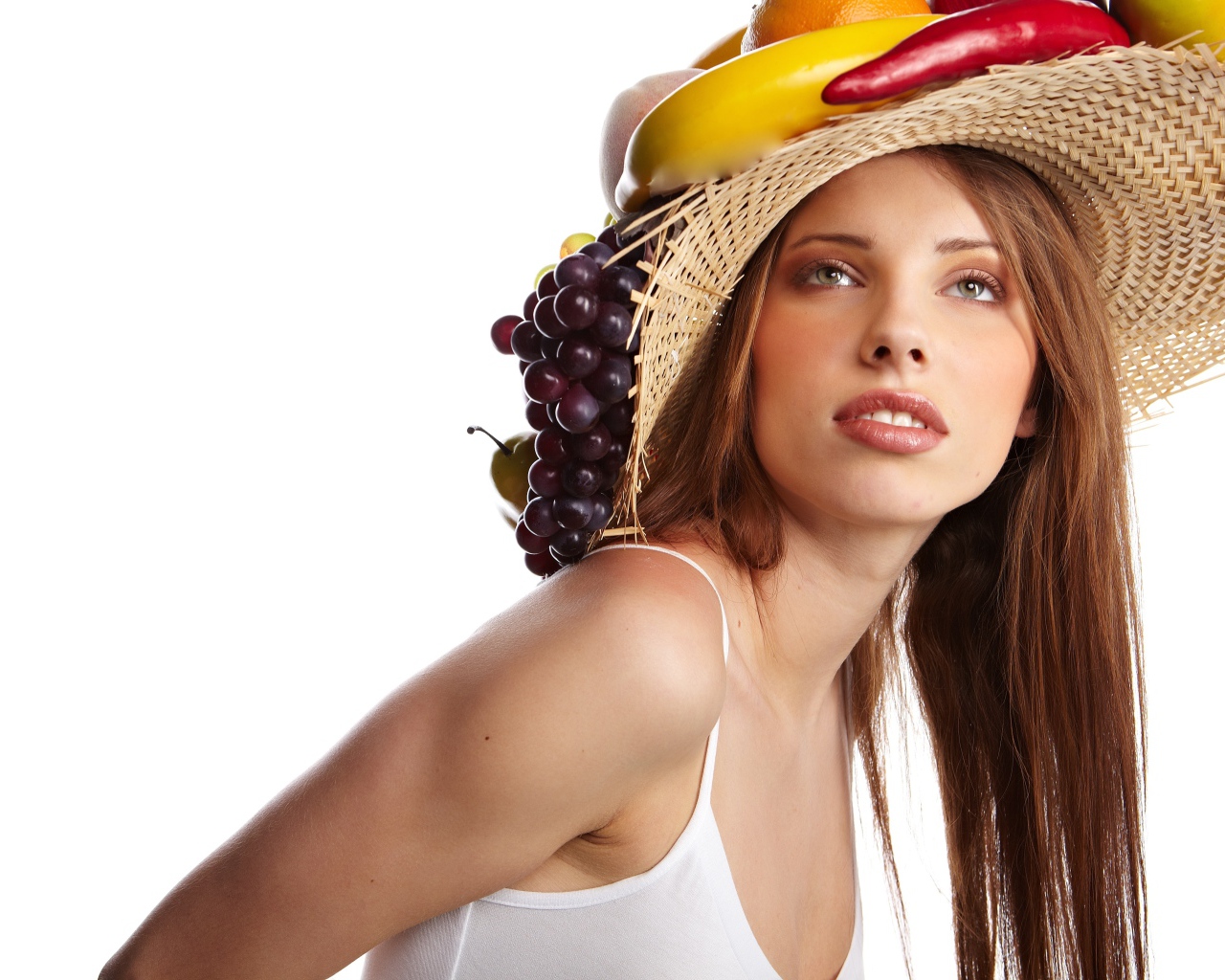 Нежная молодая девушка в соломенной шляпе на белом фоне