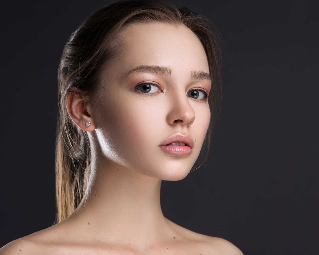 Нежная настоящая девушка шатенка на сером фоне