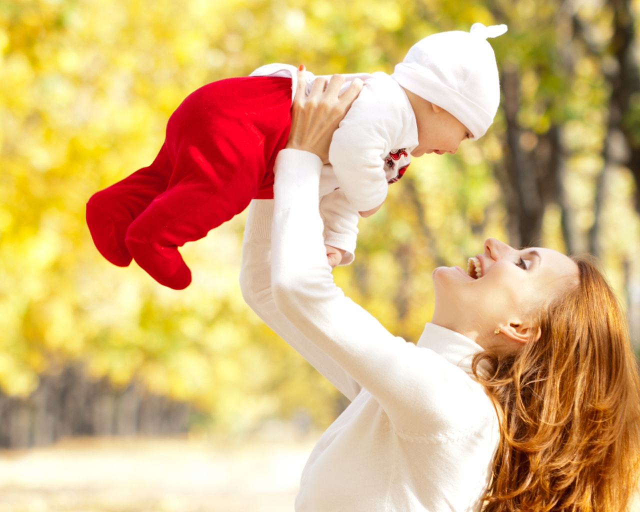 Счастливая девушка с младенцем на руках