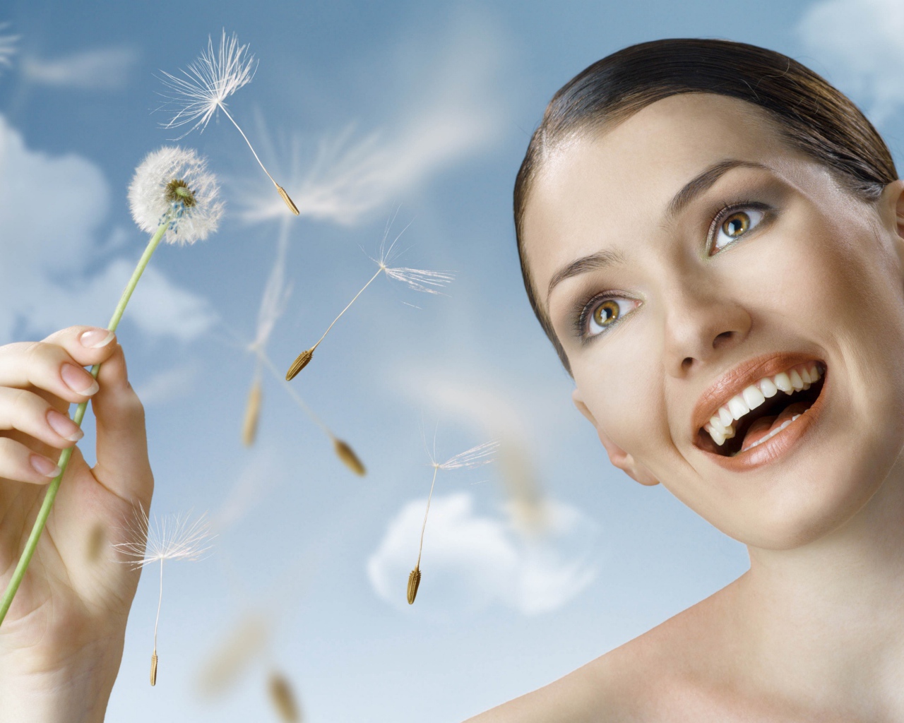Счастливая девушка с одуванчиком в руке 