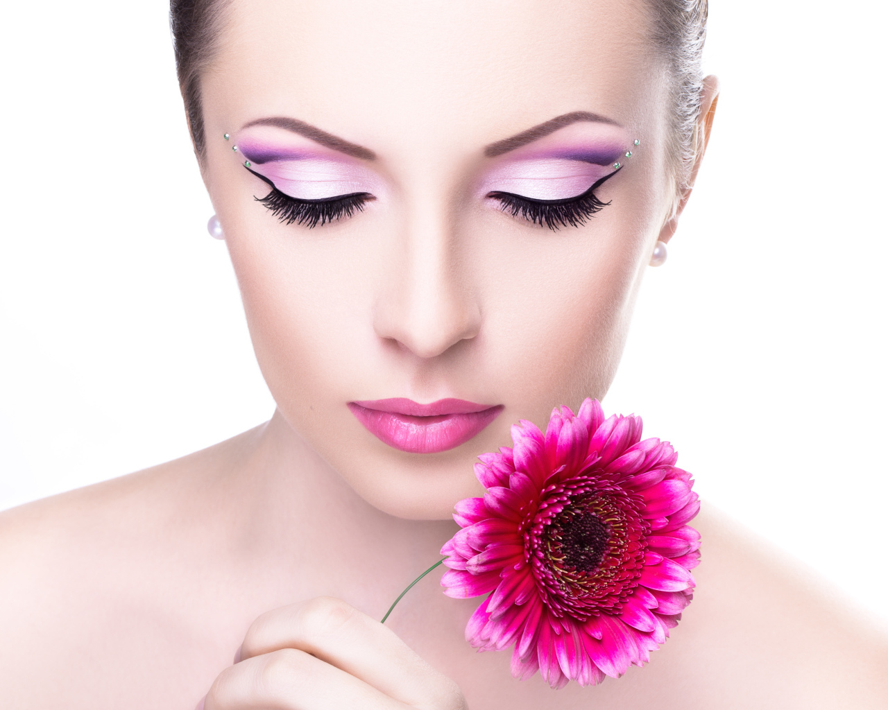 Model girl with a gentle make-up with a pink gerbera flower in her hand