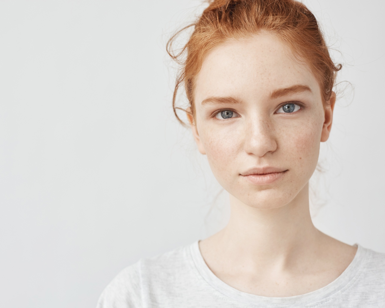 Рыжеволосая девушка на сером фоне