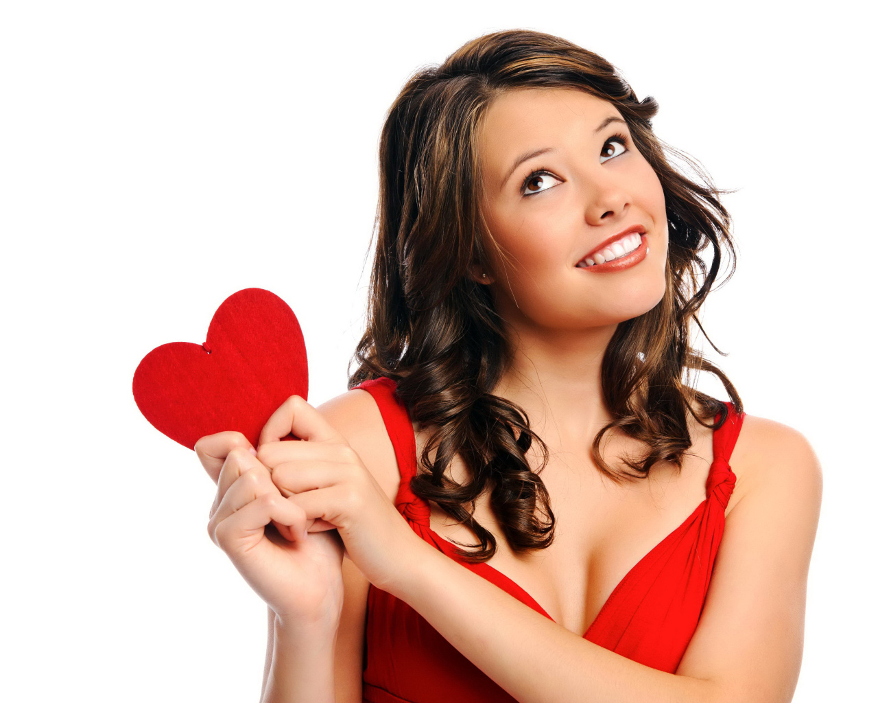 Улыбающаяся девушка с красным сердечком в руках на белом фоне