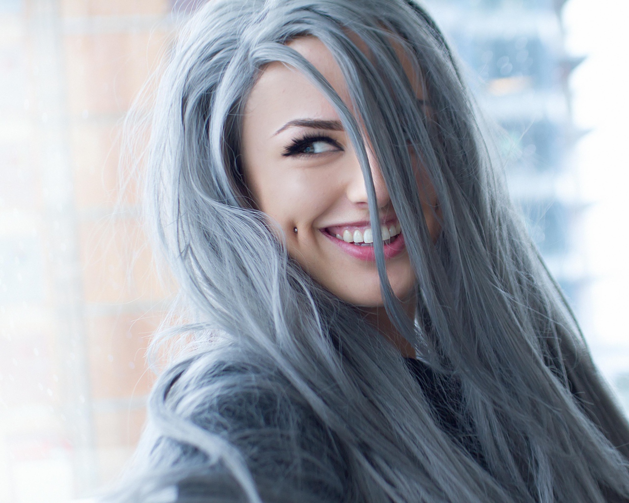 Улыбающаяся эпатажная девушка с пирсингом