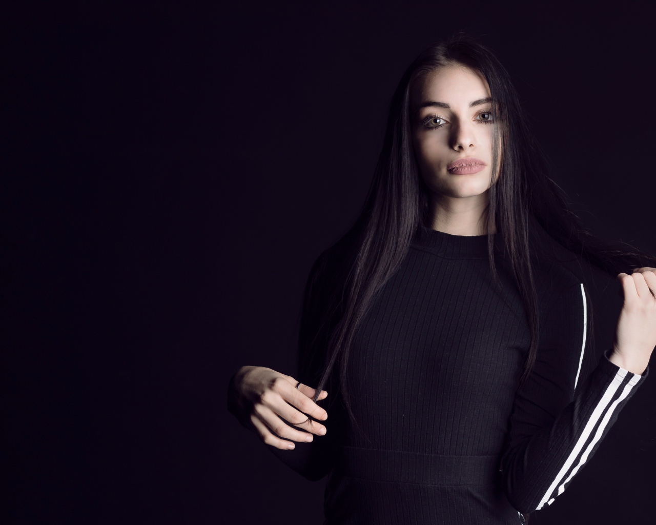 Эффектная брюнетка в черном наряде на черном фоне