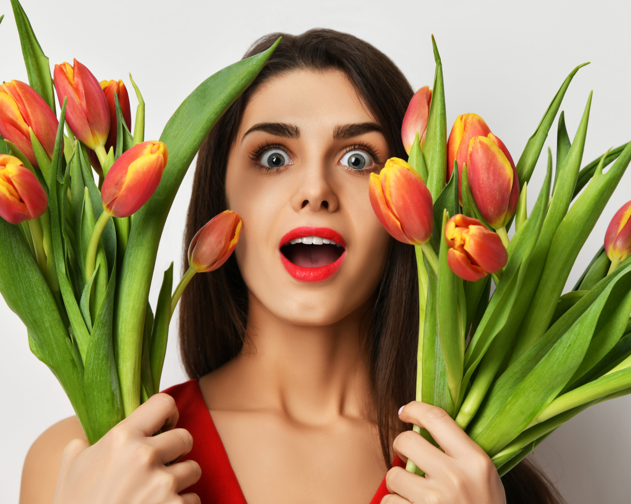 Удивленная шатенка с букетами тюльпанов
